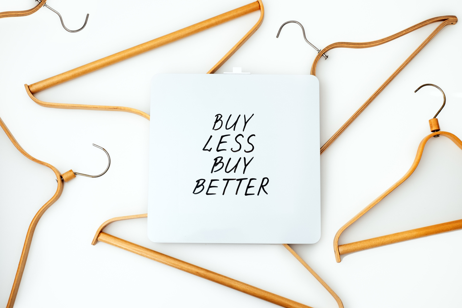 Sustainable Consumption and Production. Circular Economy, Sustainable Fashion Concept with Wooden Clothes Hangers and Text Buy Less, Buy Better